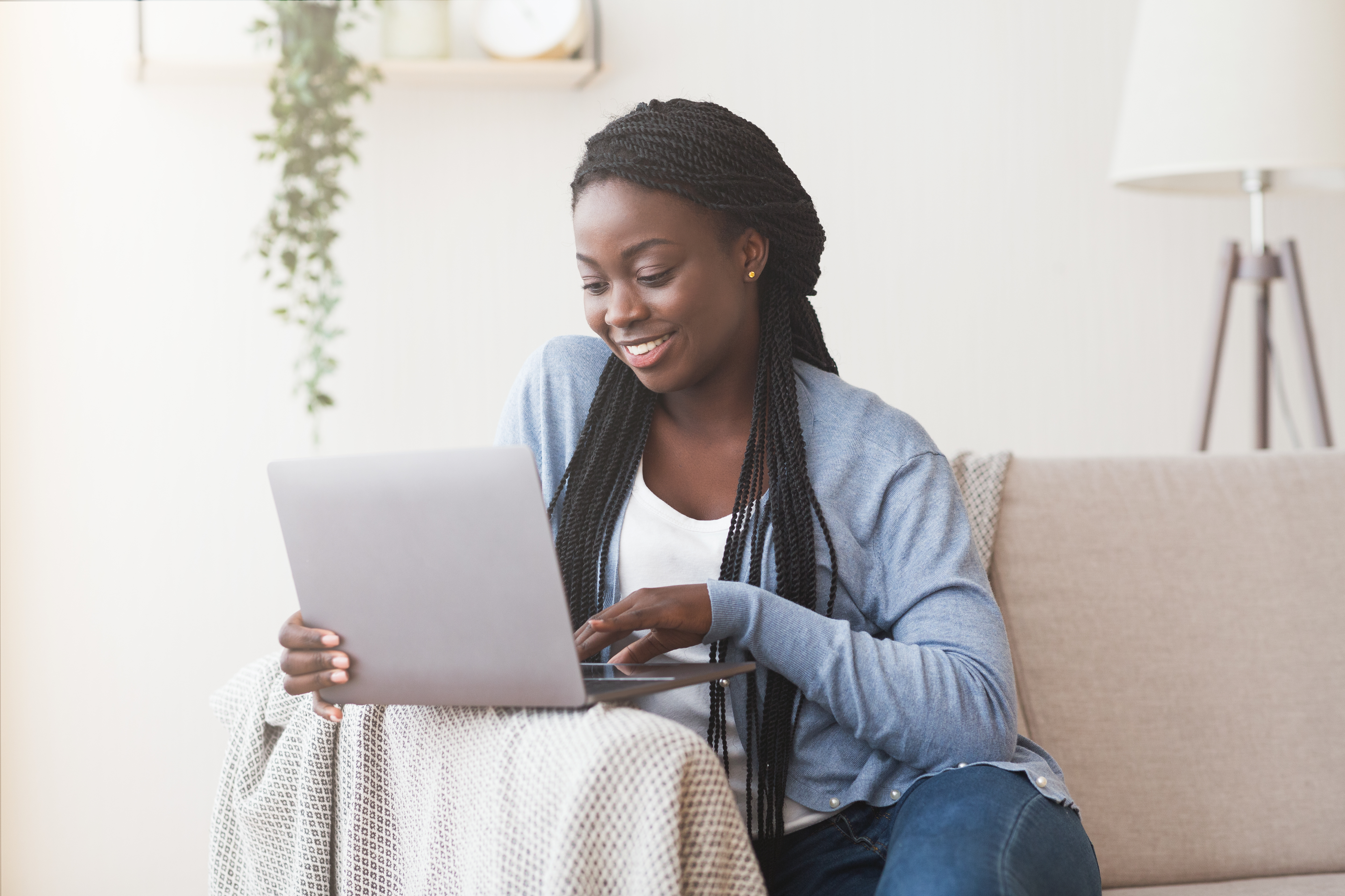 Woman at home on her couch with a laptop
