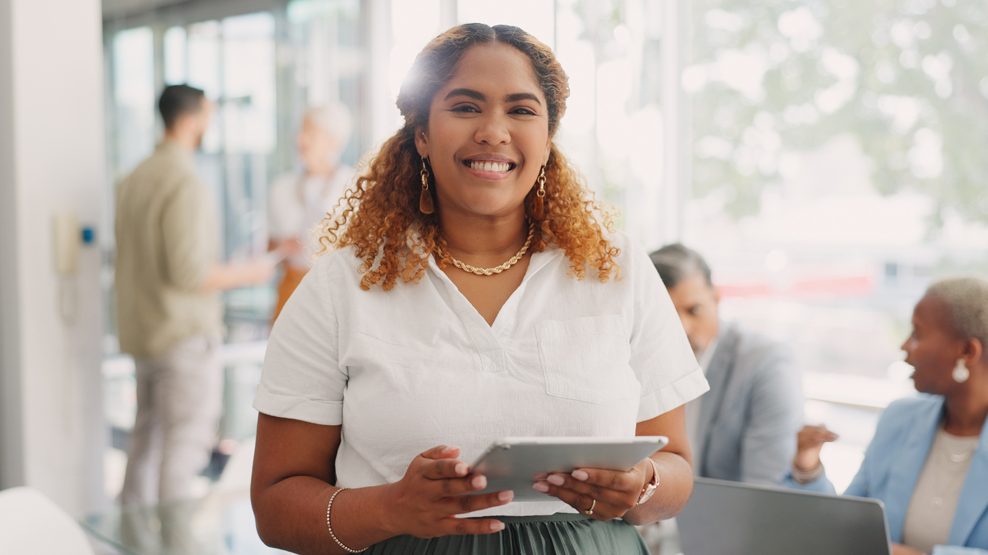 Financial advisor smiling and holding a tablet.