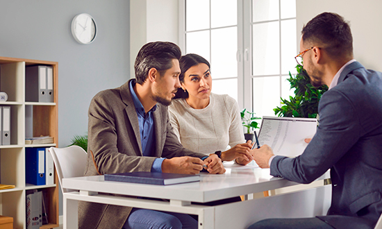 Couple discussing loan options with their bank.
