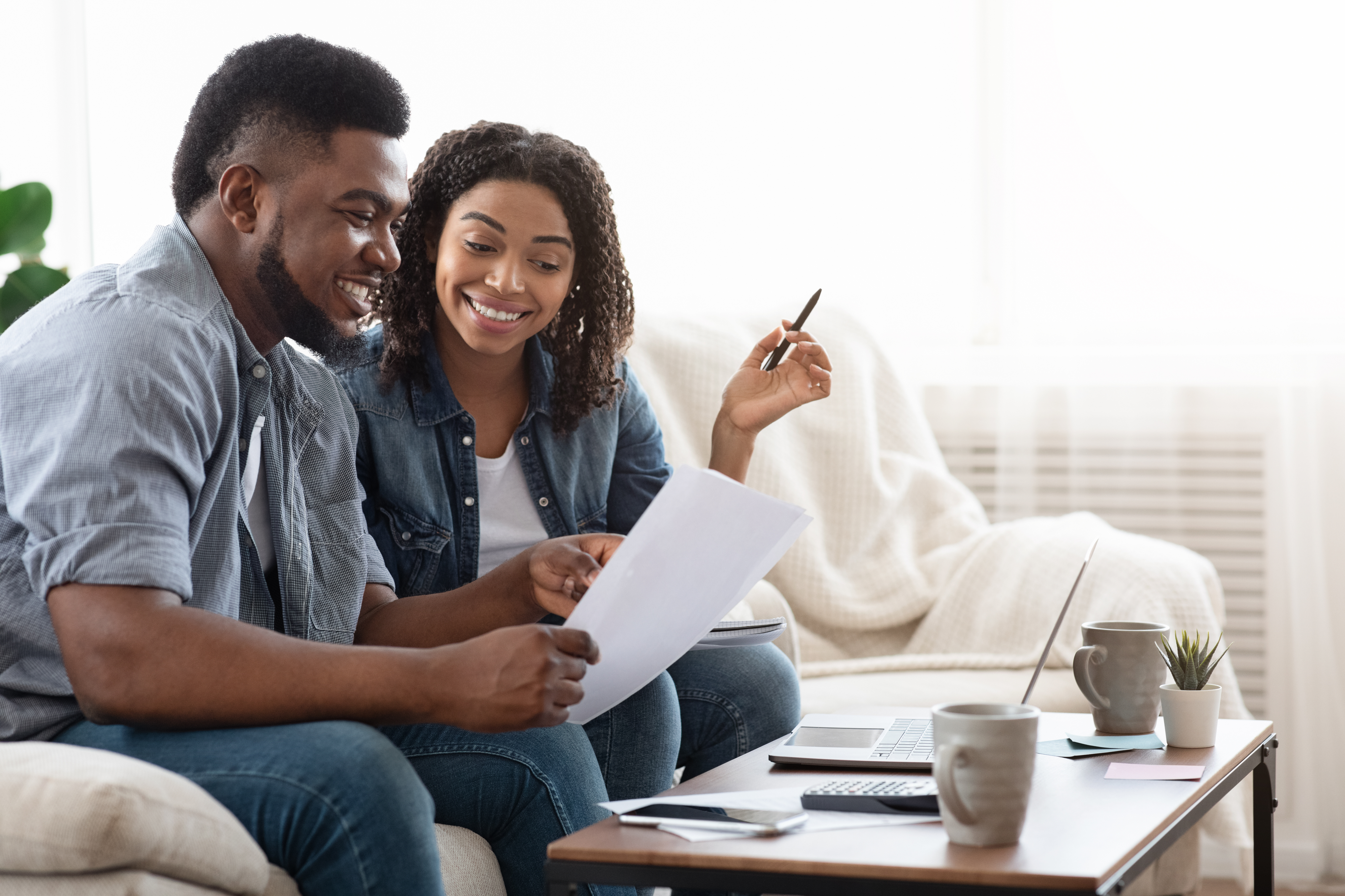 couple sitting on couch with laptop