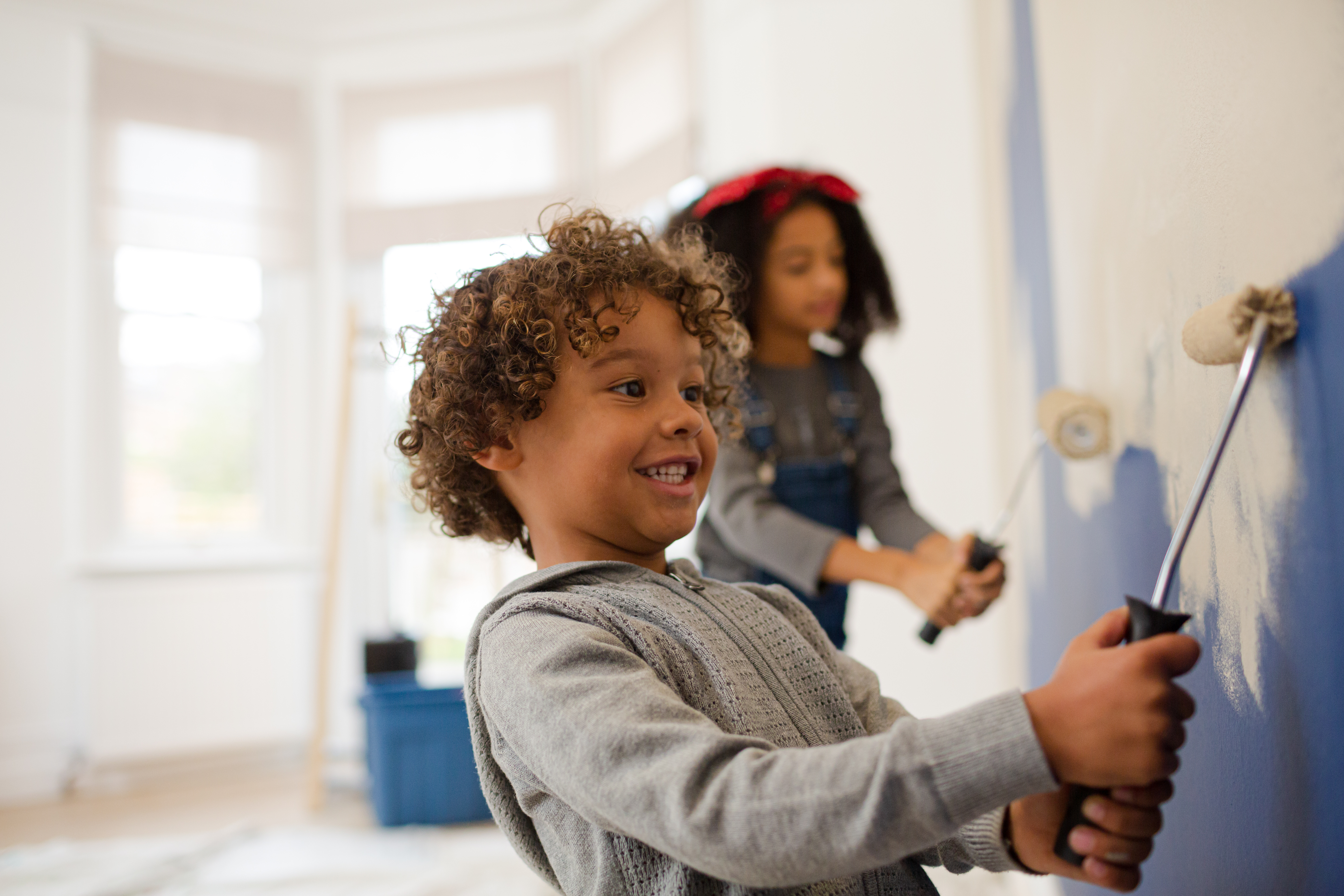 two kids painting a room blue