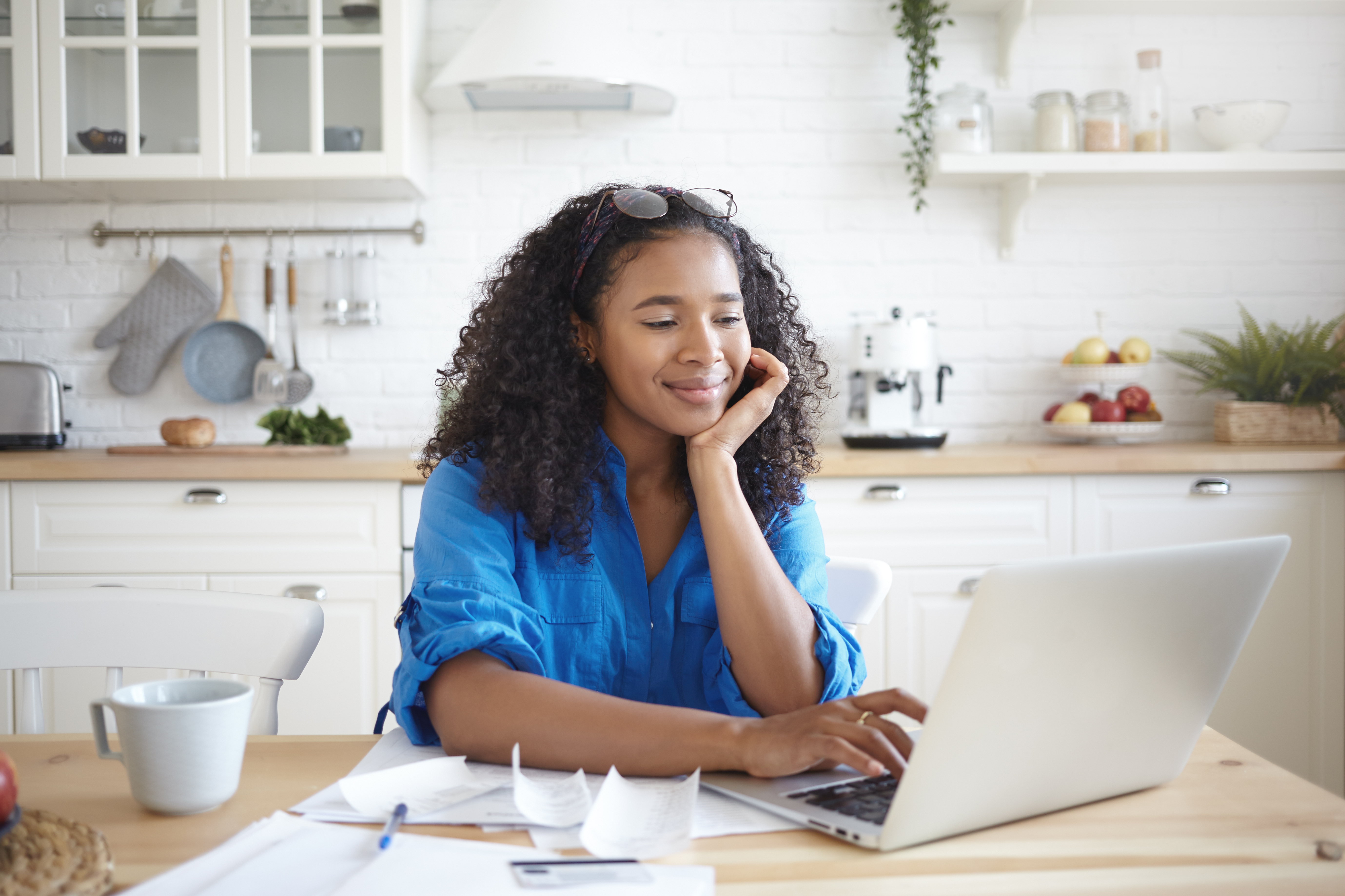 woman in her kitchen on a laptop