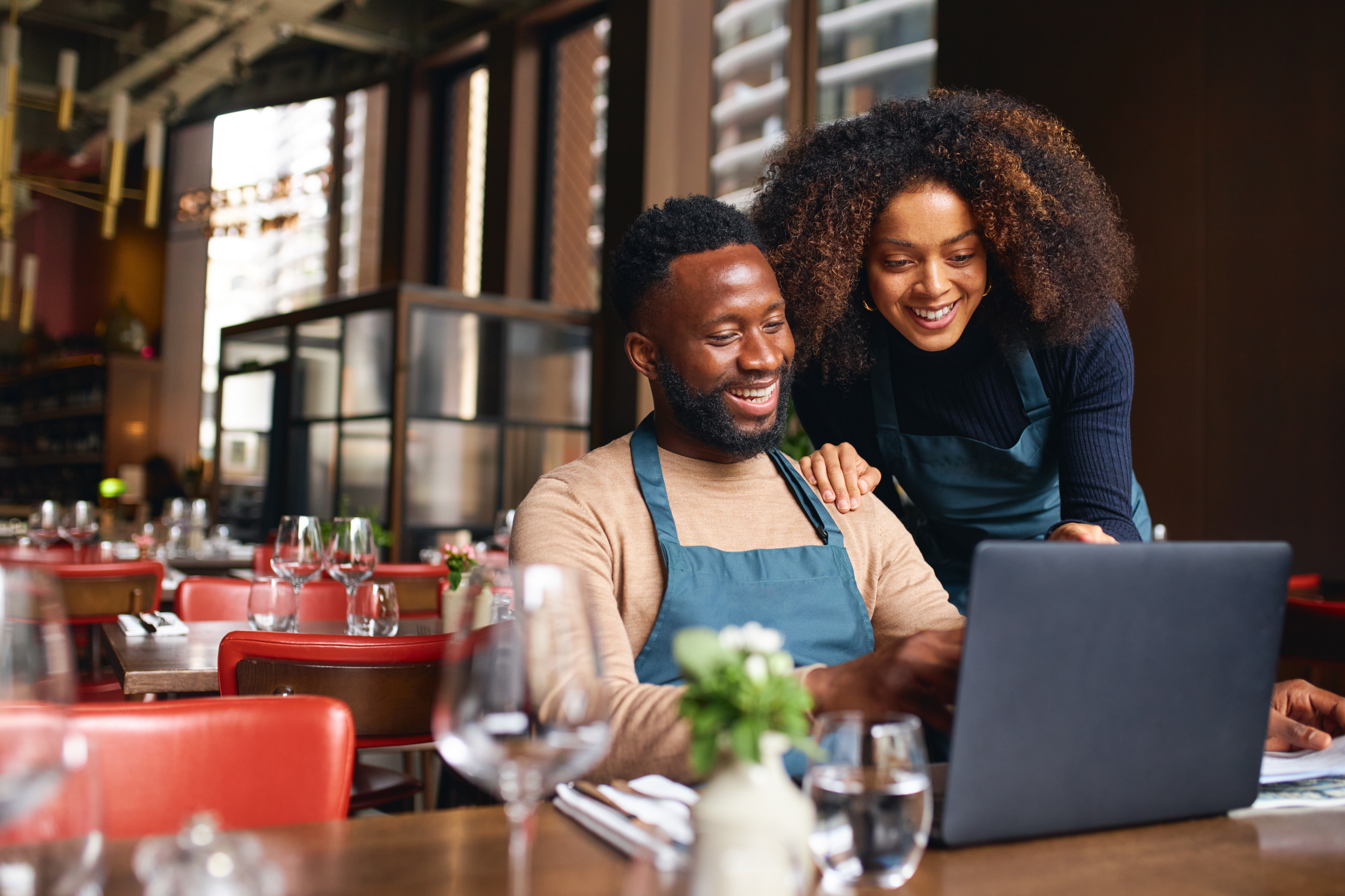 couple who own restaurant on laptop